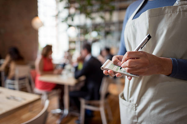 close up on a woman working at a restaurant as a waitress and holding a notepad