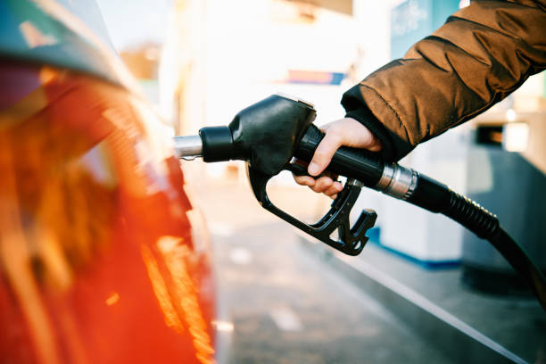 close up of a hand in a gas pump fueling a car during energy crisis
