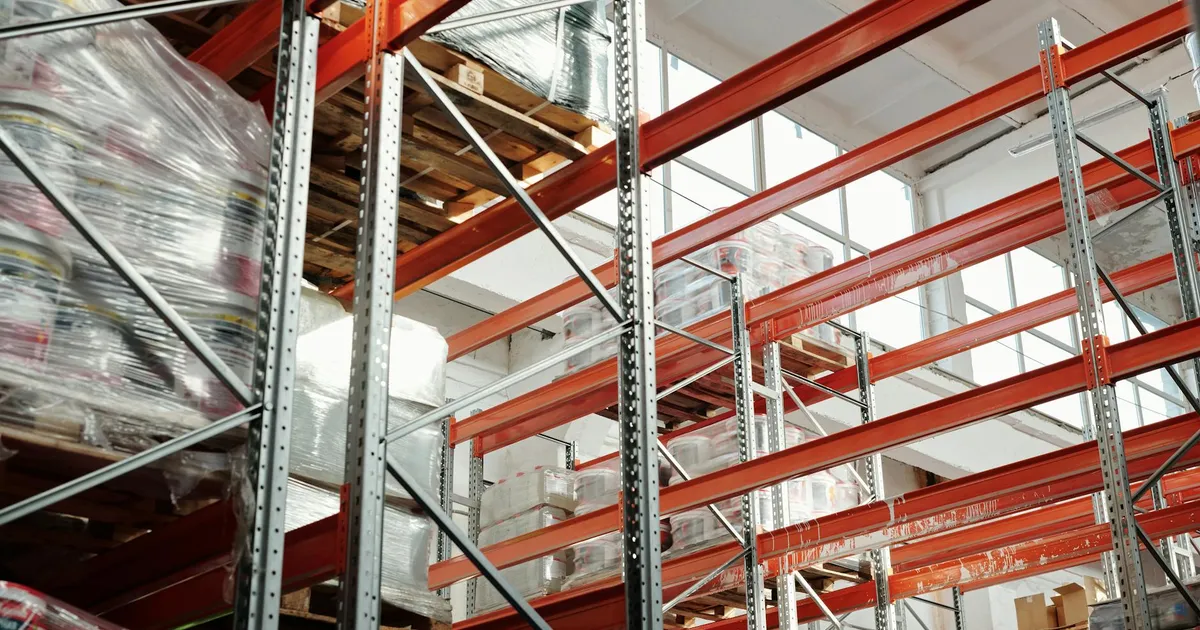 Bright modern warehouse featuring pallets and storage racks for logistics and inventory management.