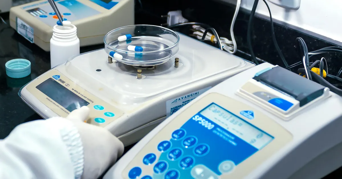 Close-up of laboratory equipment with capsules, capturing pharmaceutical analysis.