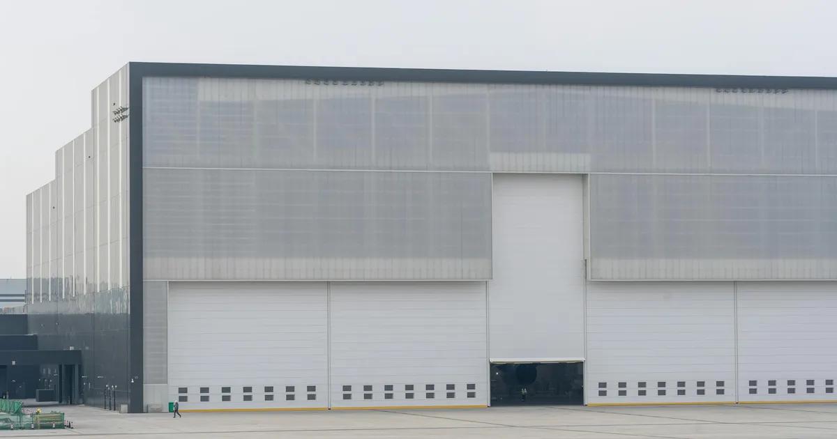 Front view of a large modern warehouse with closed doors, showcasing industrial architecture