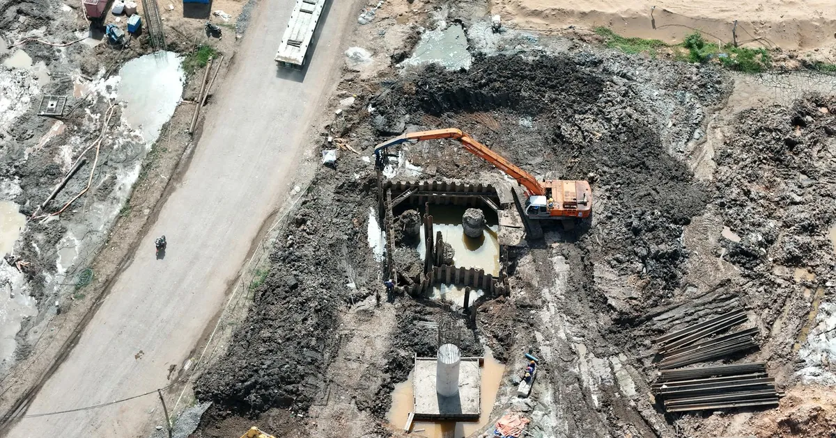 Top view of construction site showing an excavator working in muddy terrain.
