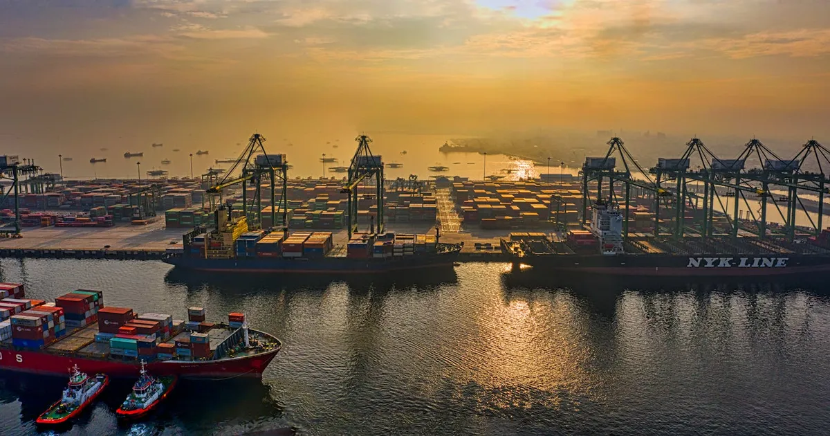 Dynamic aerial view of a bustling container port in Jakarta, Indonesia during sunset.
