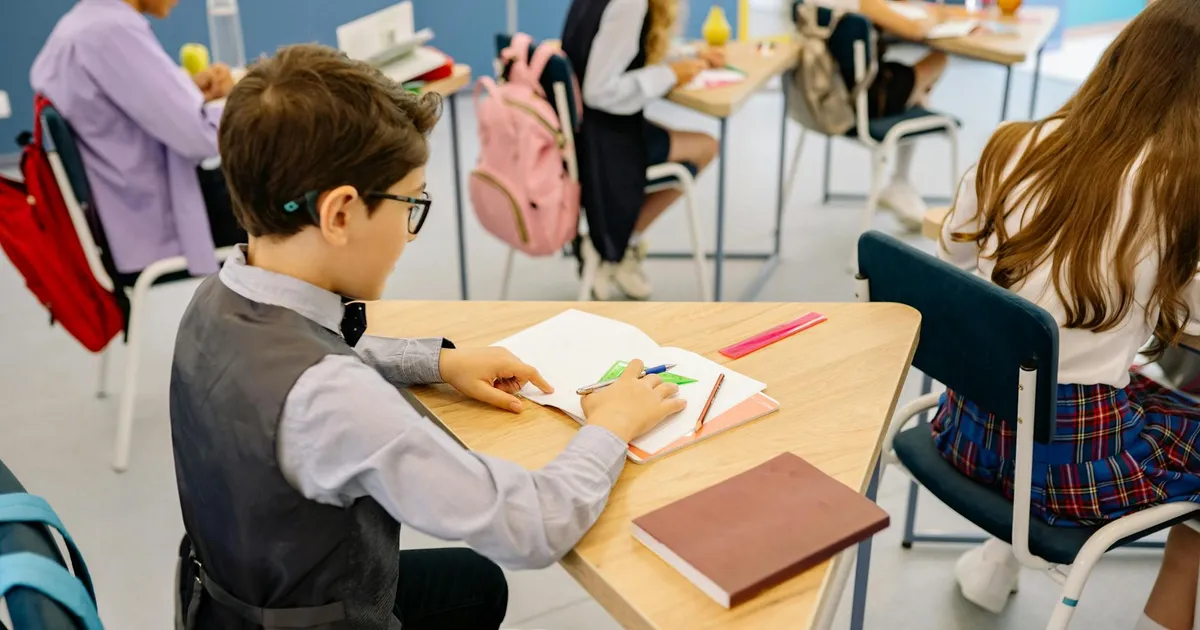 A group of students actively participating in a classroom learning session, focused on their work.