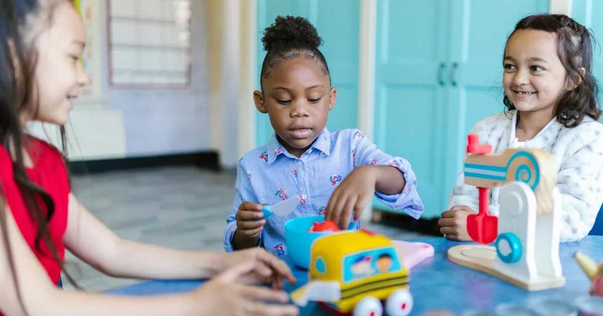 Young children playing and learning with toys in a bright classroom setting.