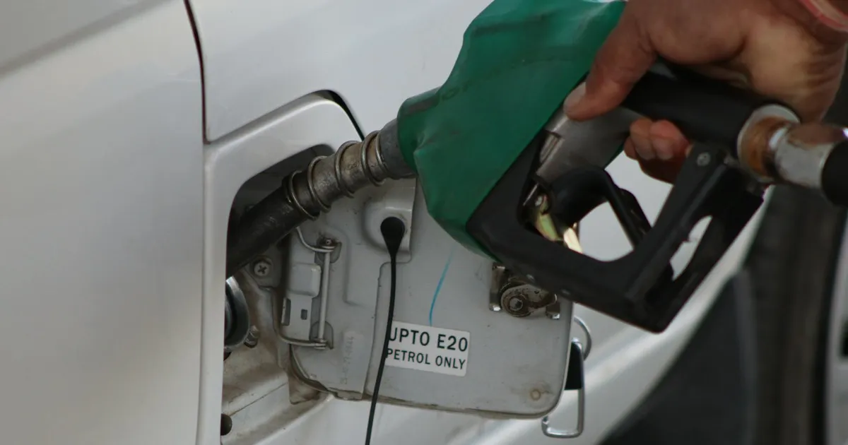 Close-up of a hand refueling a vehicle. E20 petrol pump nozzle in use.