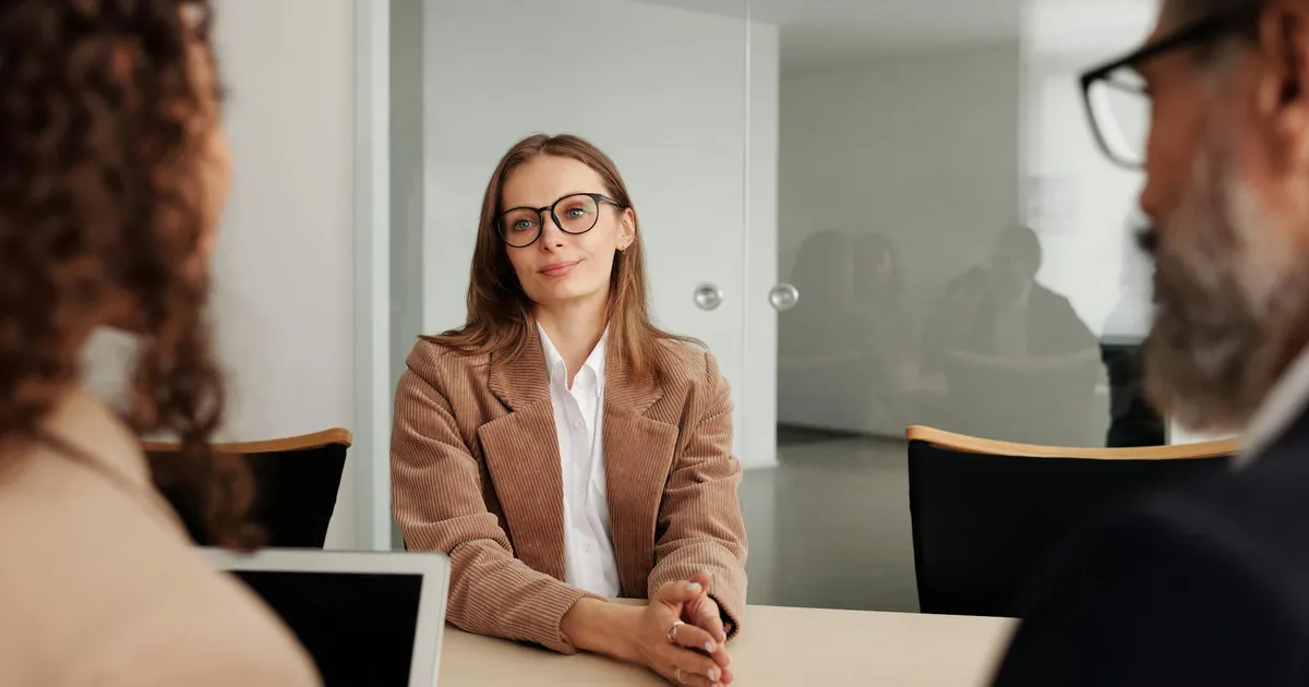 Young woman attending a job interview in a modern office, showcasing confidence and professionalism.