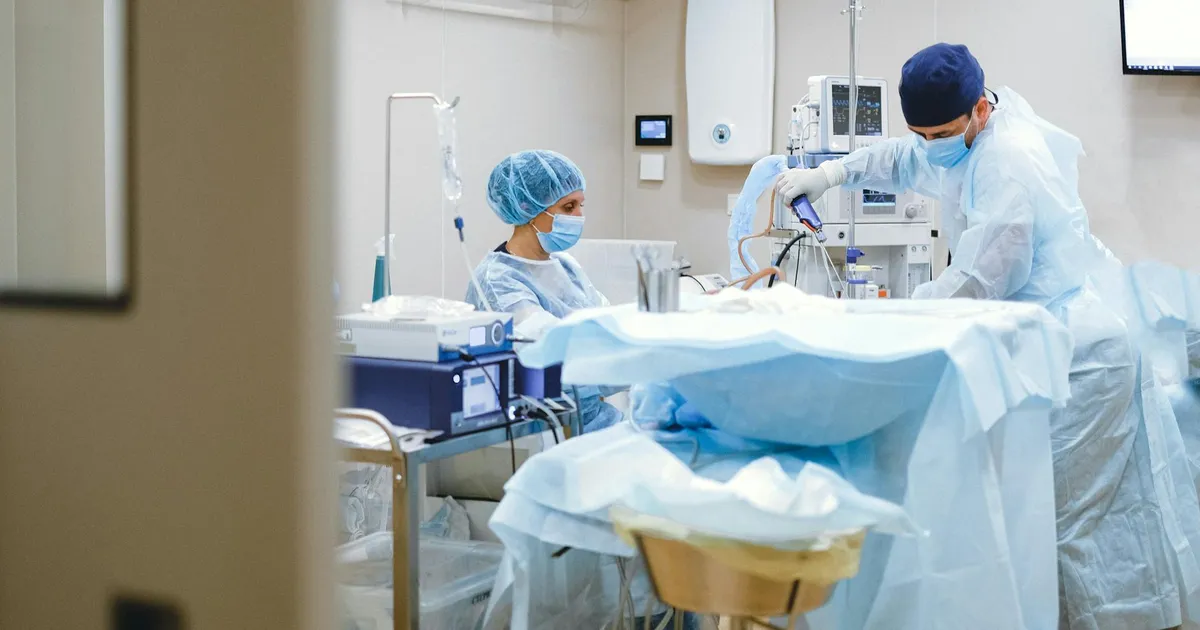 Surgeons and medical staff in a sterile operating room conducting a surgical procedure.