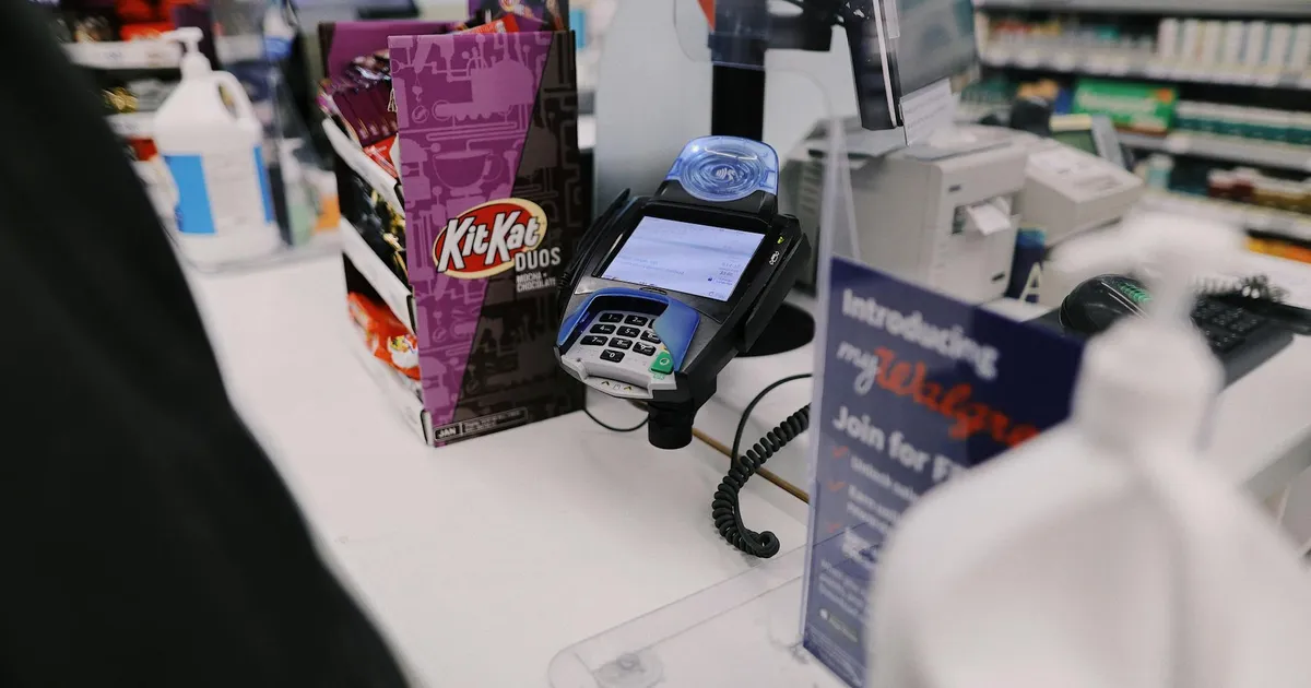 Close-up view of a retail checkout counter with a credit card reader and various goods.