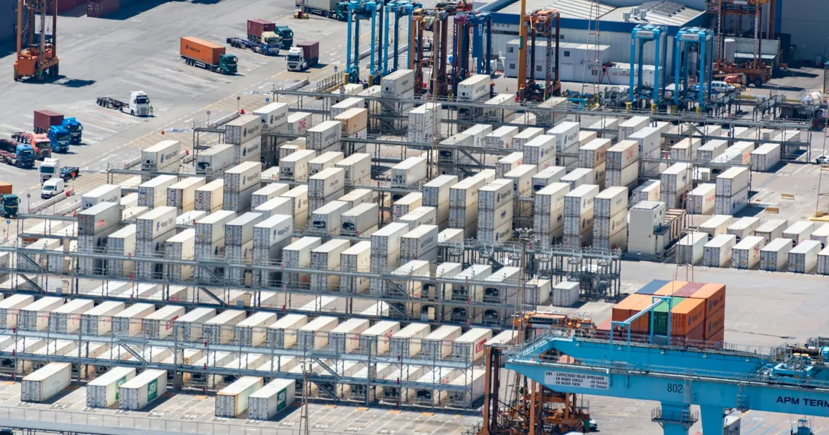Bird's eye view of a logistics warehouse with shipping containers and trucks.