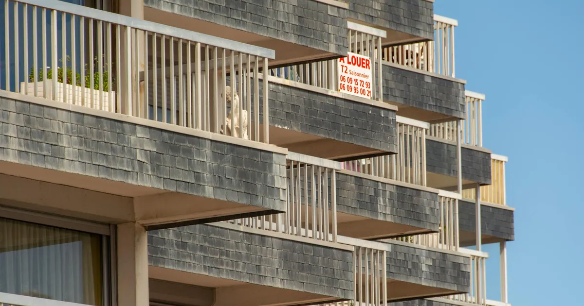 Close-up of modern building balconies with a visible rental sign.