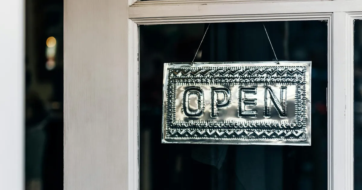 Metal open sign hanging on a shop door in Paso Robles, California.