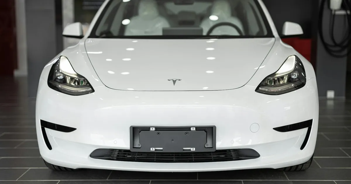 Sleek white electric car on display in a modern dealership showroom.