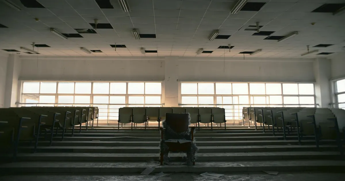 Desolate lecture hall with empty seating, displaying a sense of abandonment and neglect.