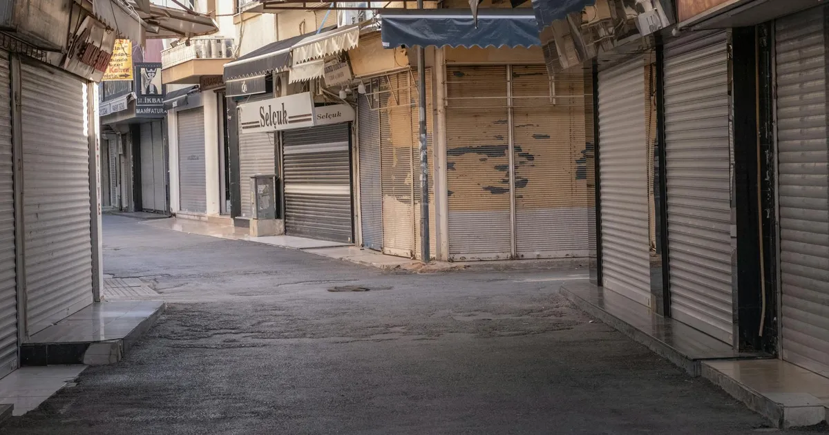 A deserted street in İzmir, Türkiye, lined with closed shops and shuttered storefronts.
