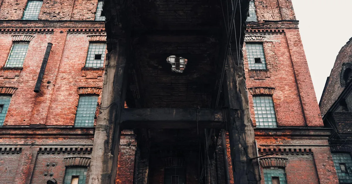 Low angle view of an old, abandoned brick industrial building with vintage architecture.