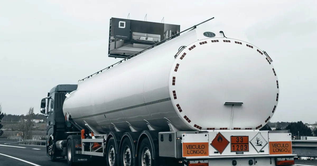 Rear view of a large tanker truck transporting fuel on a highway, emphasizing logistics and transportation.