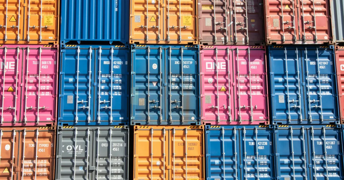 Stacked multicolored shipping containers at a Hamburg port, showcasing industrial logistics.