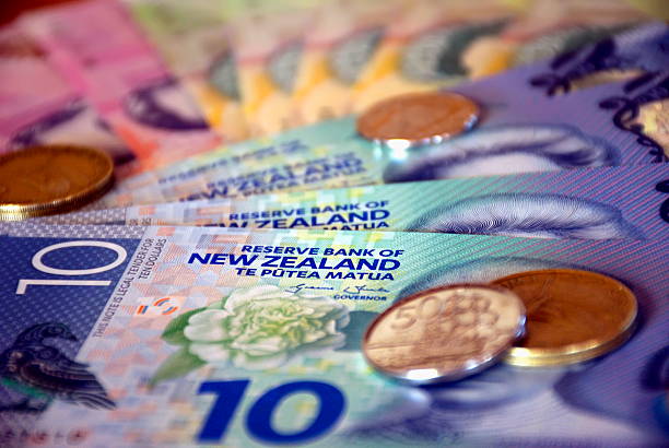 a mixture of new zealand bank notes and coins.