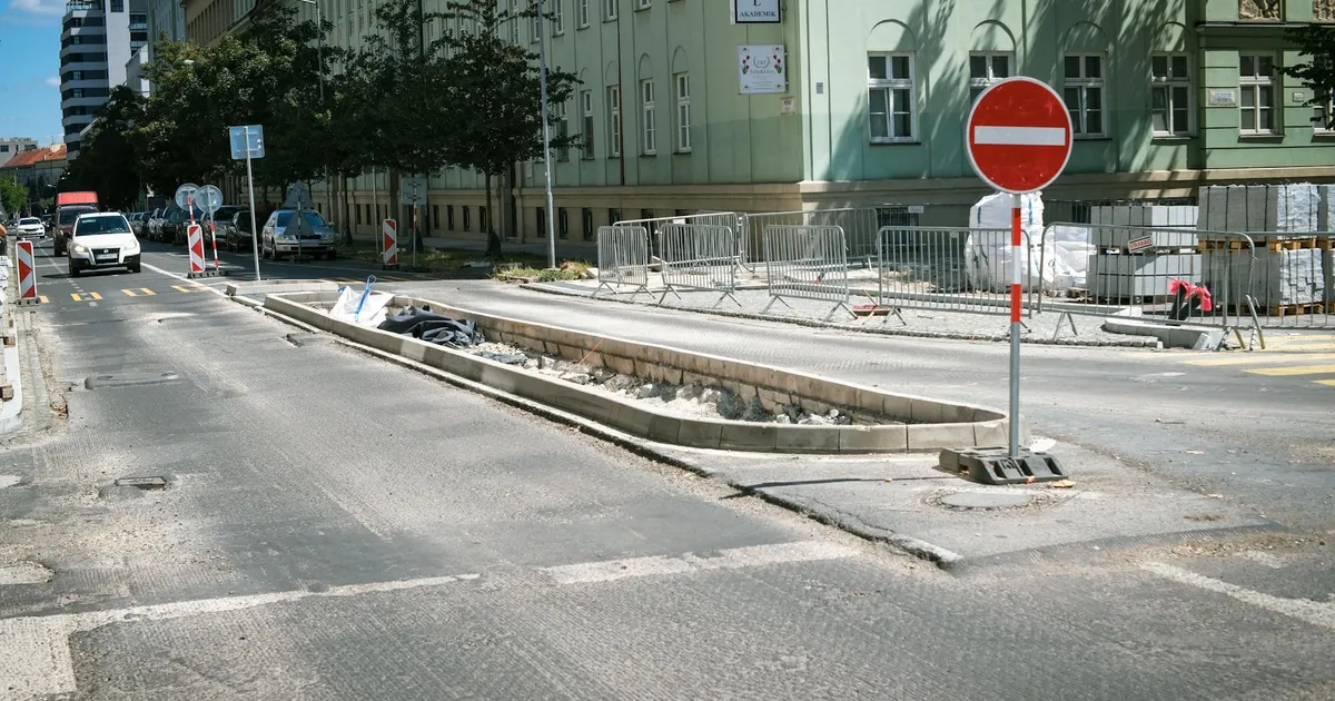Street construction scene in Bratislava, Slovakia with traffic signs and barriers.