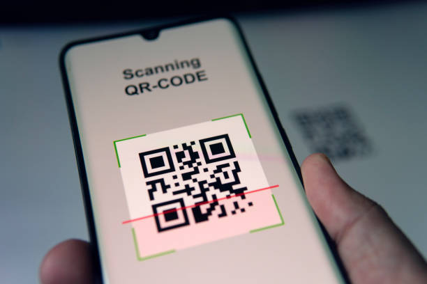 close up of businessman scanning a barcode using cell phone