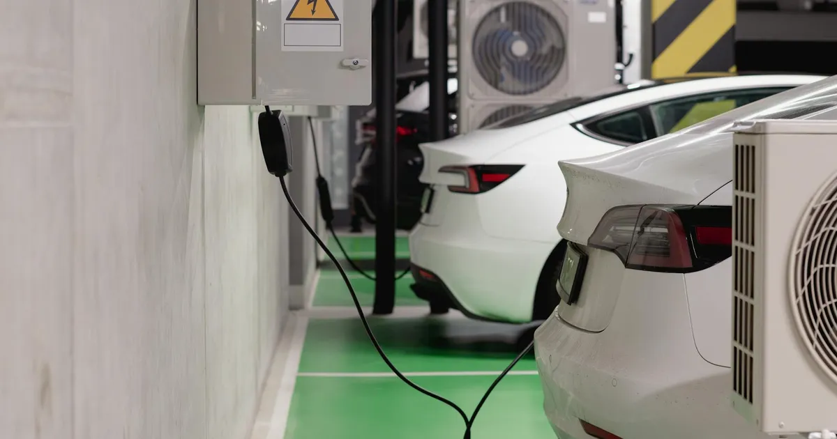 Electric vehicles charging at an indoor station in a modern underground garage.