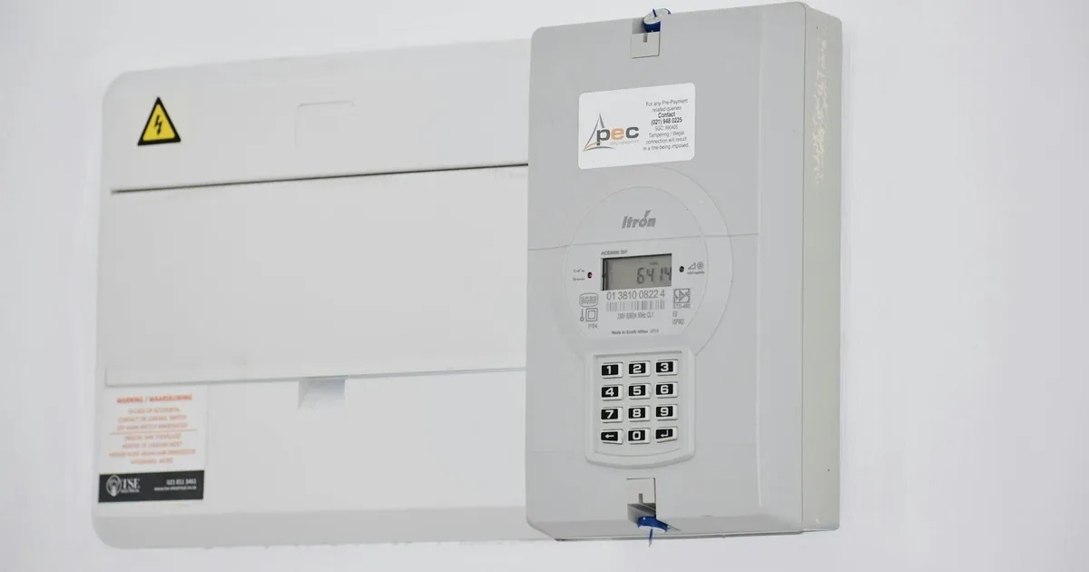 Electrical meter and fuse box on a white wall in Cape Town, South Africa, for energy monitoring or billing.