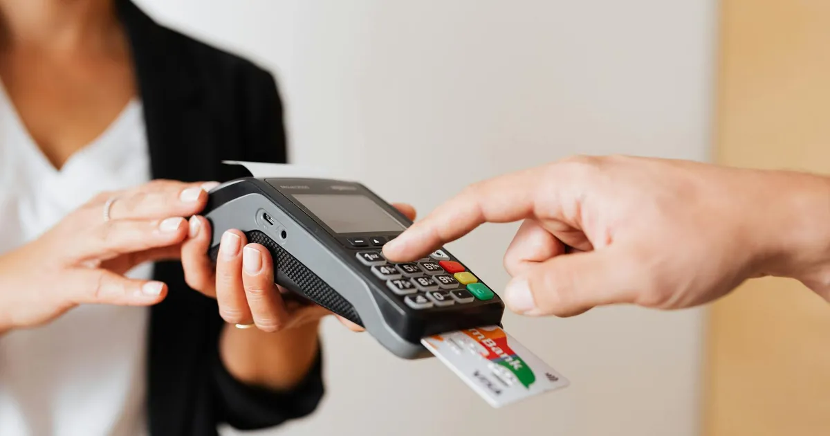 A customer using a contactless payment terminal for secure and cashless transactions indoors.