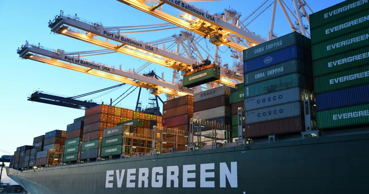 An Evergreen container ship loading at the Port of Baltimore during daytime.