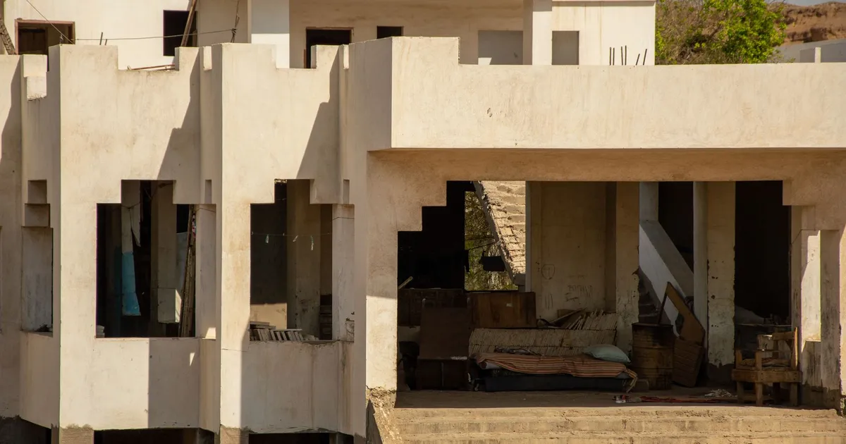 A partially abandoned residential building with incomplete construction details.