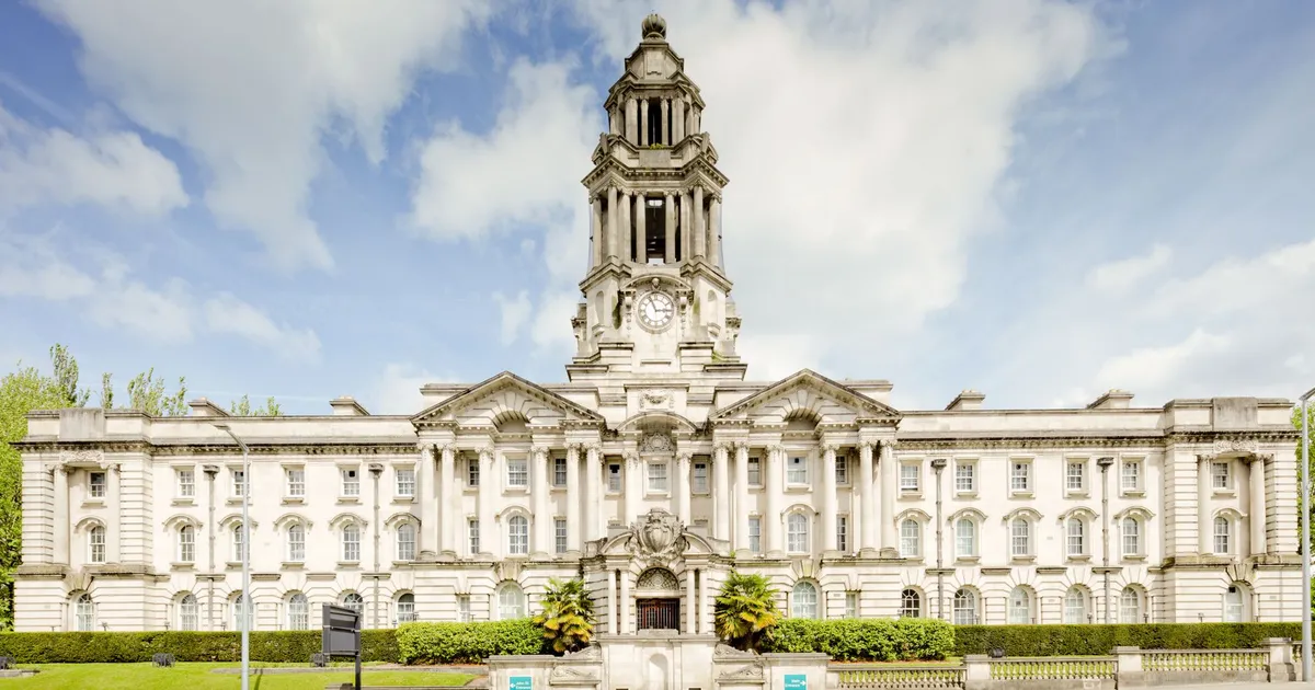 Front view of the iconic Stockport Town Hall with a clear blue sky backdrop.