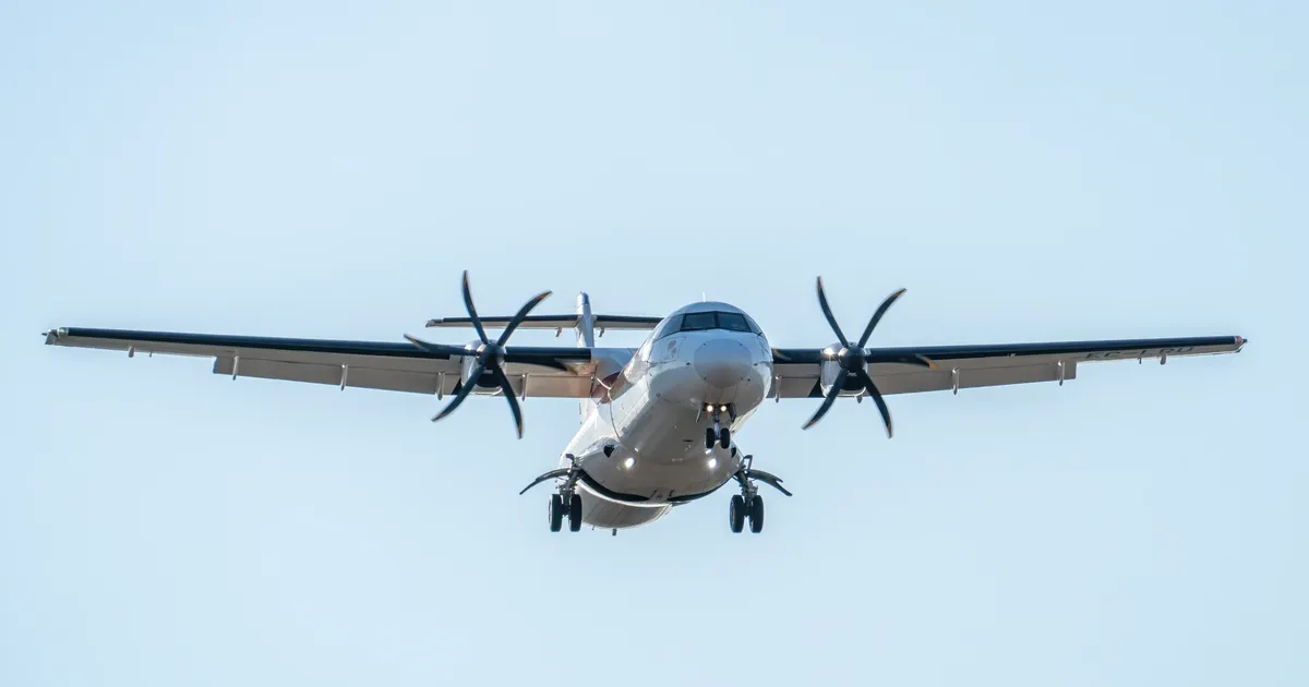 ATR 72 aircraft captured mid-flight with landing gear down at Manises Airport, Spain.