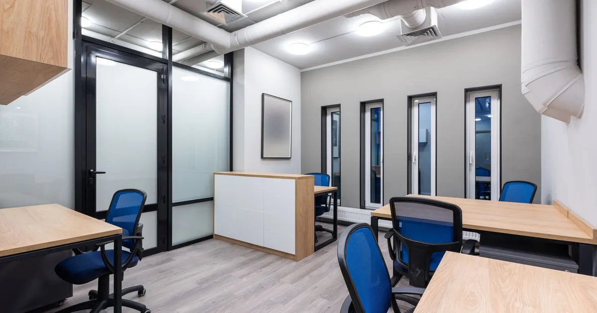 Interior of new contemporary spacious workplace with wooden desks and blue office chairs