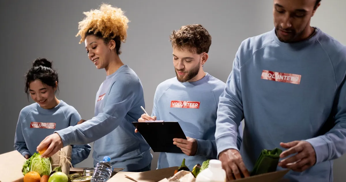 Four diverse volunteers pack food donations with teamwork and dedication.