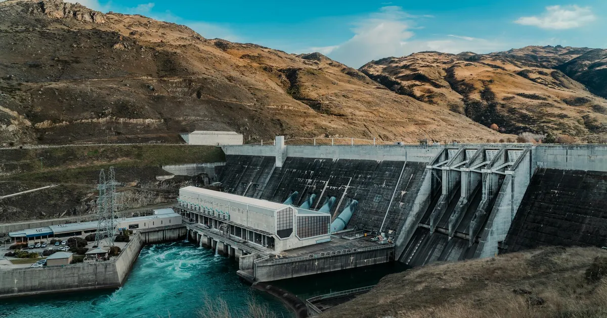 Powerful hydroelectric dam nestled in a rugged mountain landscape with clear blue waters.