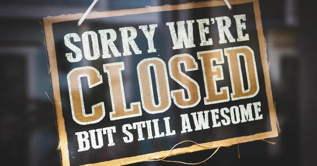 A playful closed sign on a shop door reading 'Sorry We're Closed But Still Awesome'.