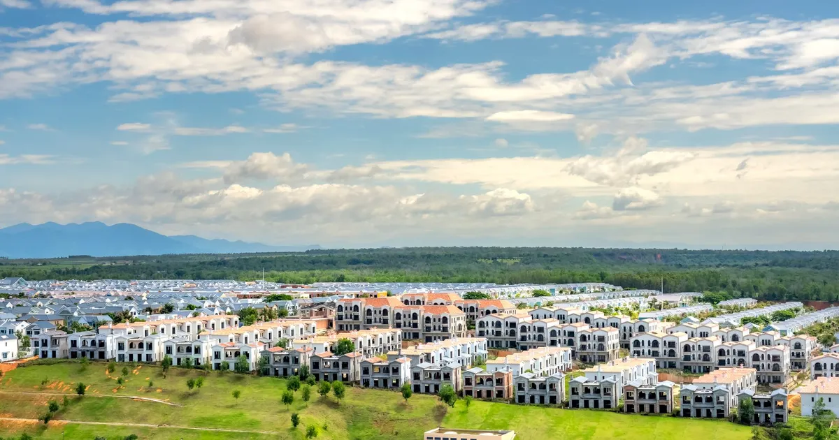Panoramic aerial snapshot of a suburban residential area with lush greenery under a blue sky.