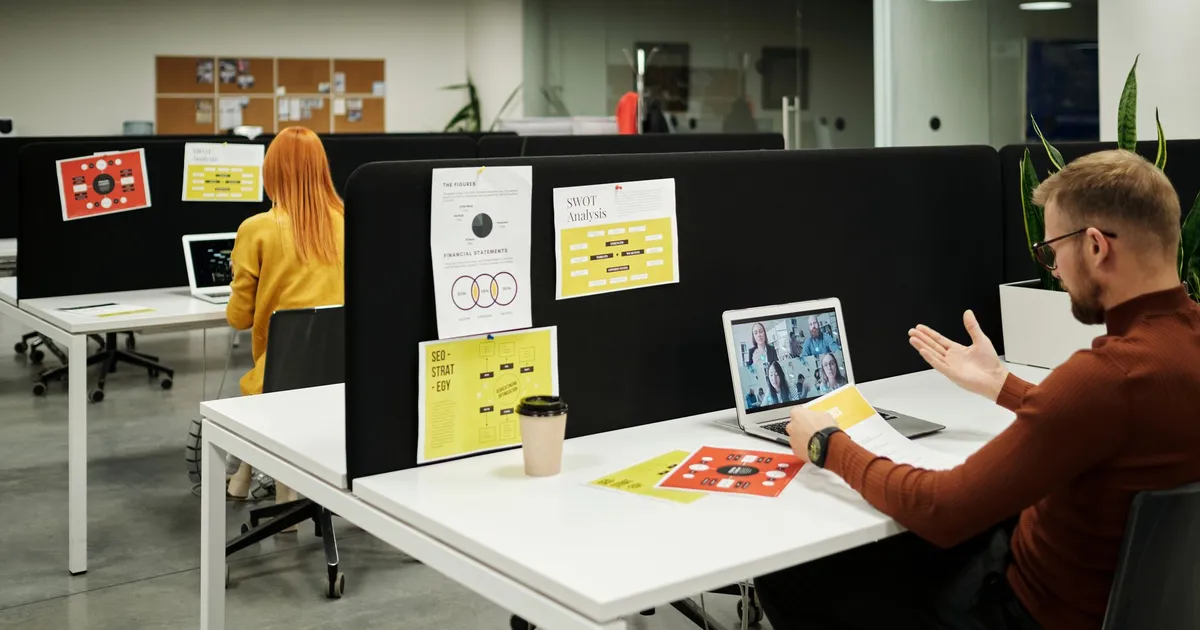 Colleagues working and collaborating virtually at a stylish modern office workspace.