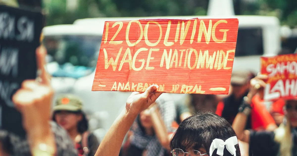 A group of protestors holding a sign demanding a 1200 living wage nationwide.