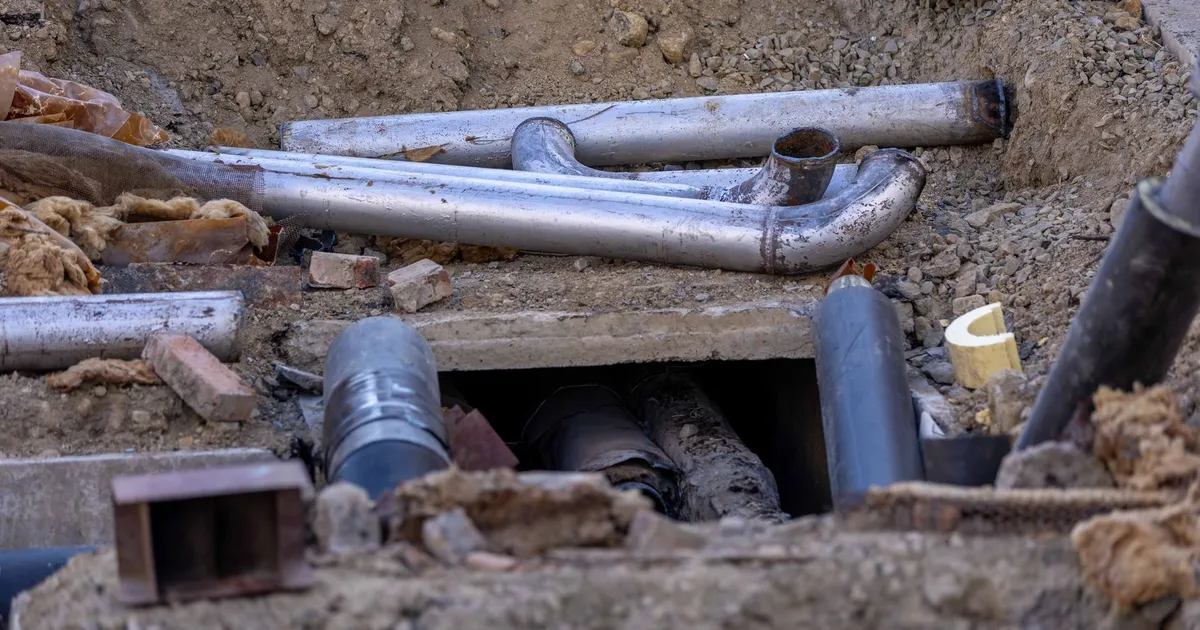 Close-up of urban pipe installation at a construction site, showing various pipes and materials.