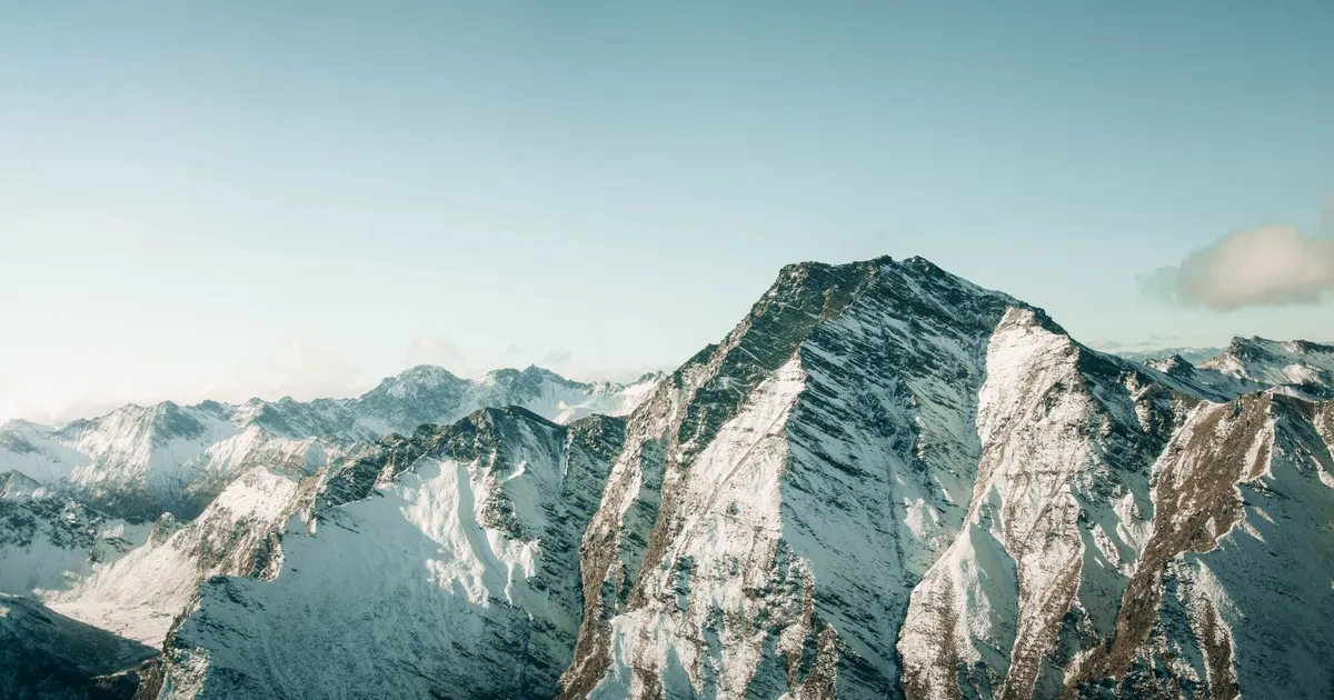 Aerial view of snow-covered mountains in Queenstown, New Zealand, showcasing breathtaking winter scenery.