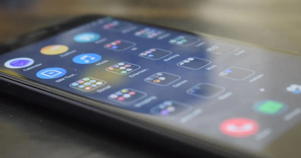 Close-up shot of a smartphone screen showing various app icons, indicating digital technology use.