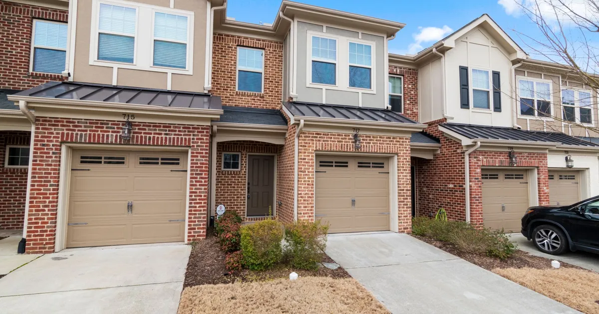 Charming row of modern townhouses featuring brick facades and attached garages.