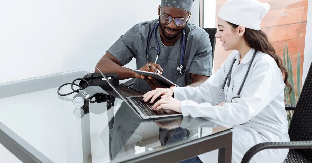 Medical professionals collaborating with digital devices in a clinical setting.