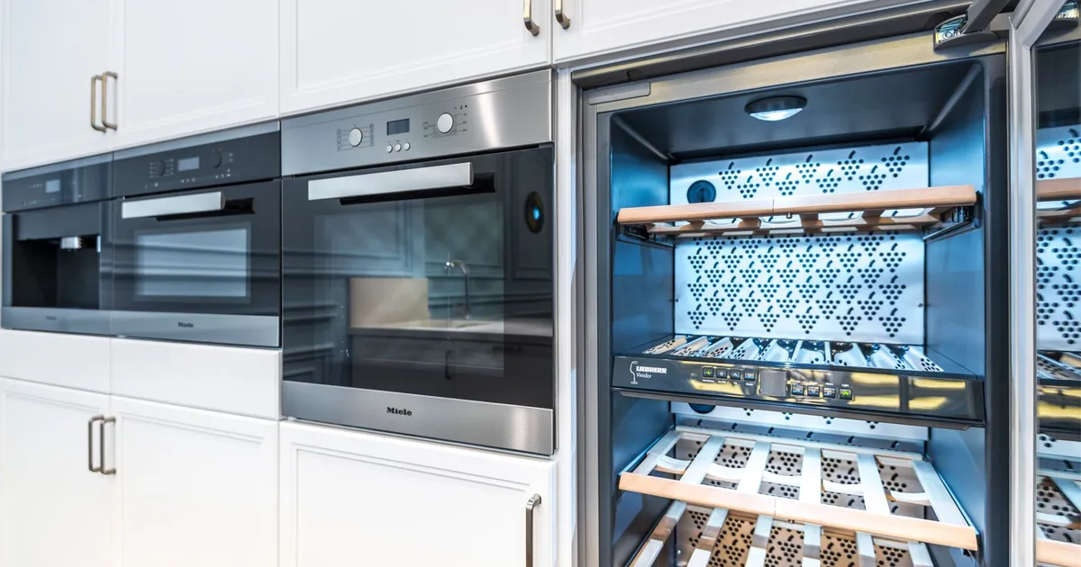 Elegant modern kitchen featuring built-in ovens and a wine cooler with stylish cabinetry.