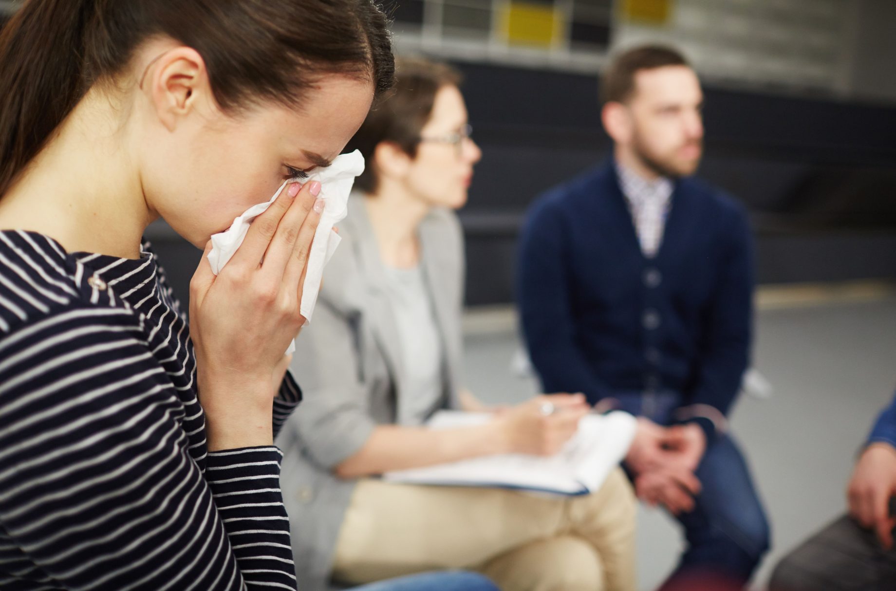 upset-woman-using-tissue-in-a-meeting