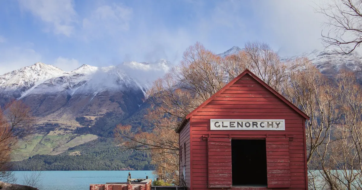 Charming red shed at Glenorchy with stunning alpine backdrop. Perfect for nature and travel enthusiasts.
