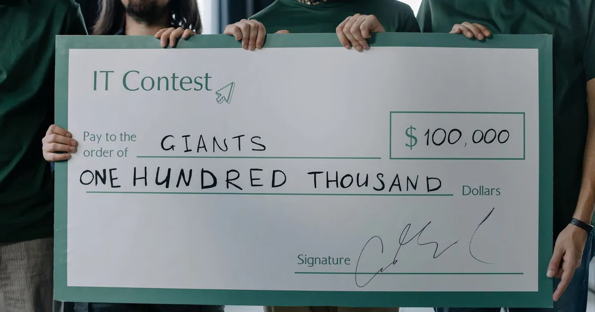 Group of men holding a $100,000 prize check after winning an IT contest.