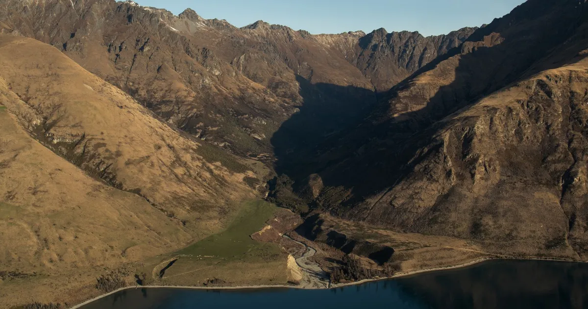 Stunning aerial view of the rugged mountains and serene water in Queenstown, New Zealand.