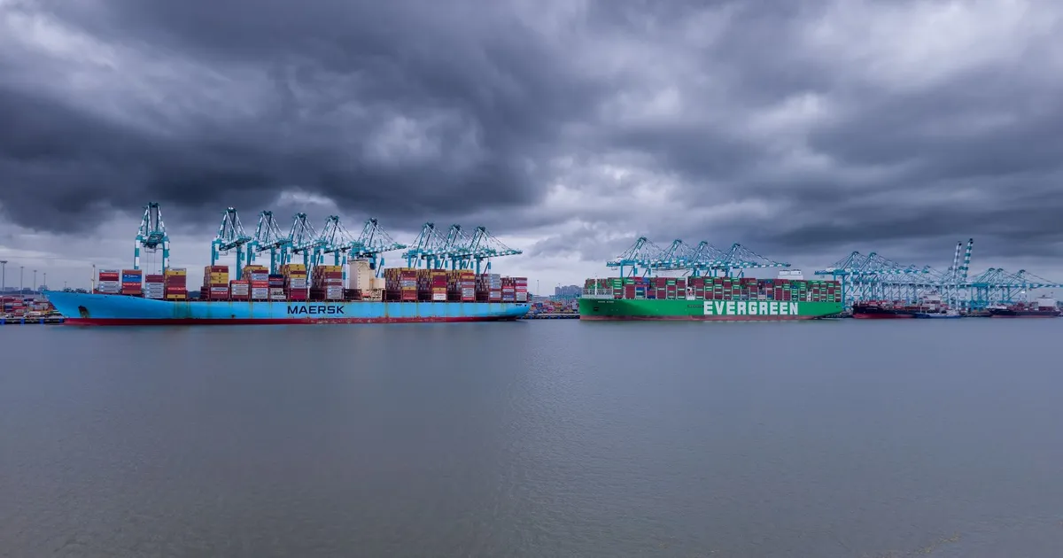 Container ships in a harbor under dramatic storm clouds.